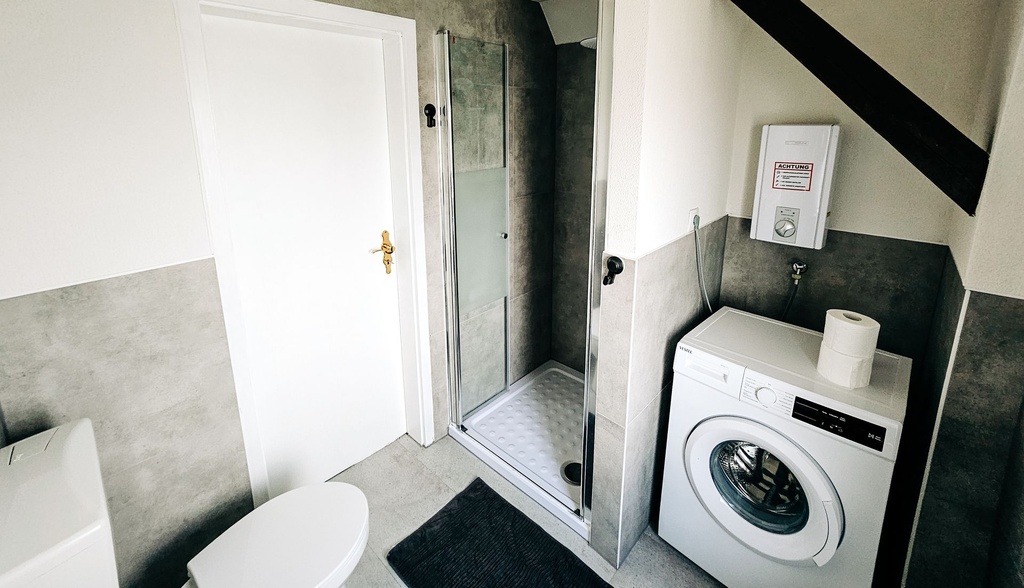 Badezimmer mit Dusche und WC & Waschmaschine